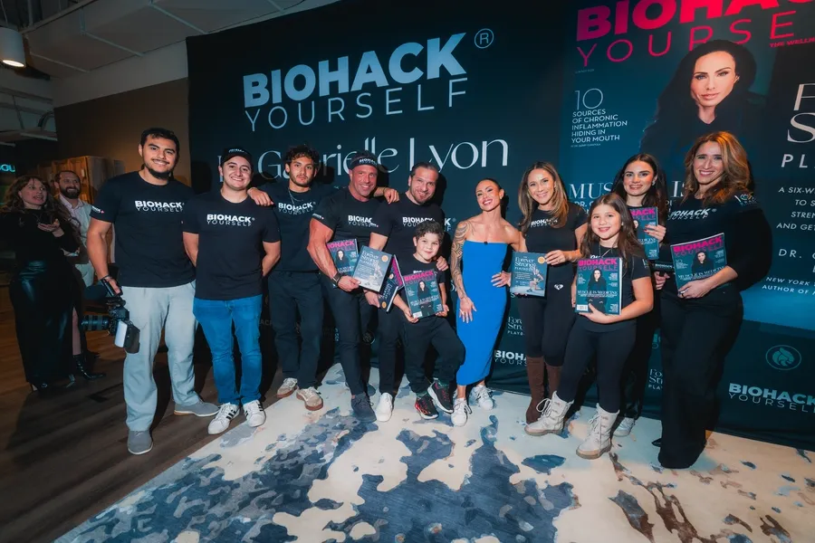 Crew holding magazines under the Gabrielle Lyon backdrop